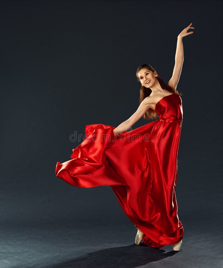 Όμορφο ballerina που χορεύει ένα μακροχρόνιο κόκκινο πέταγμα φορεμάτων στοκ εικόνες