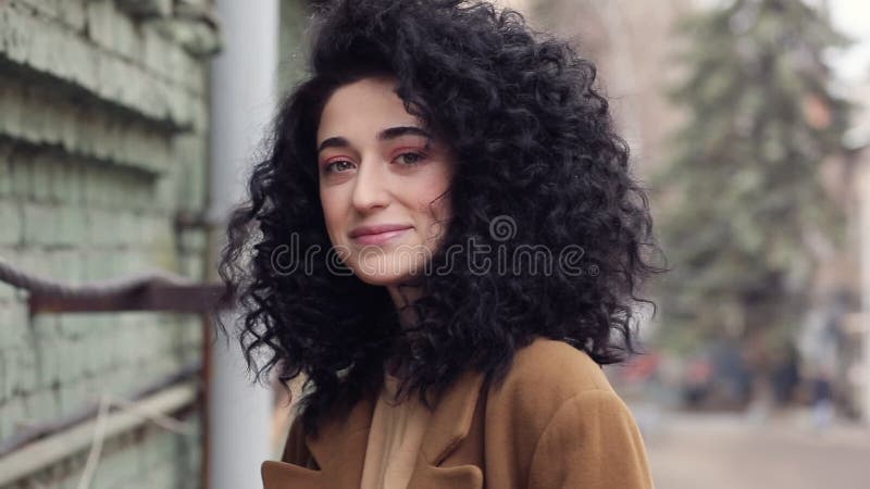 Όμορφο brunette με το afro hairstyle Χαμόγελα, γέλια, και ρωγμές το κεφάλι του