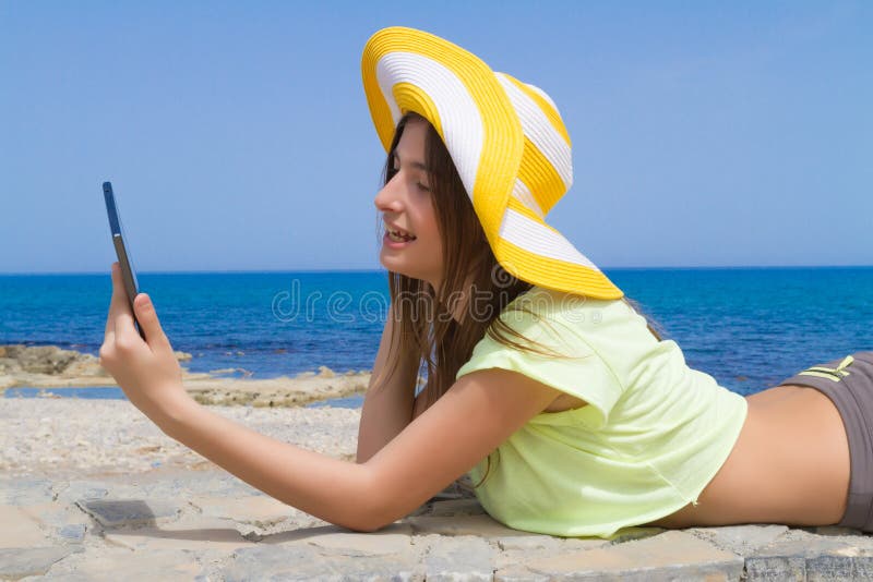 Όμορφο εφηβικό brunette χρησιμοποιώντας μια ταμπλέτα από στοκ φωτογραφίες με δικαίωμα ελεύθερης χρήσης Όμορφο εφηβικό brunette χρησιμοποιώντας μια ταμπλέτα από στοκ φωτογραφίες με δικαίωμα ελεύθερης χρήσης