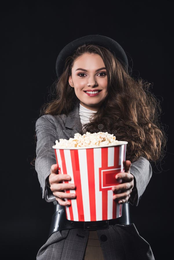 όμορφο κομψό νέο popcorn εκμετάλλευσης γυναικών και χαμόγελο στη κάμερα στοκ εικόνες