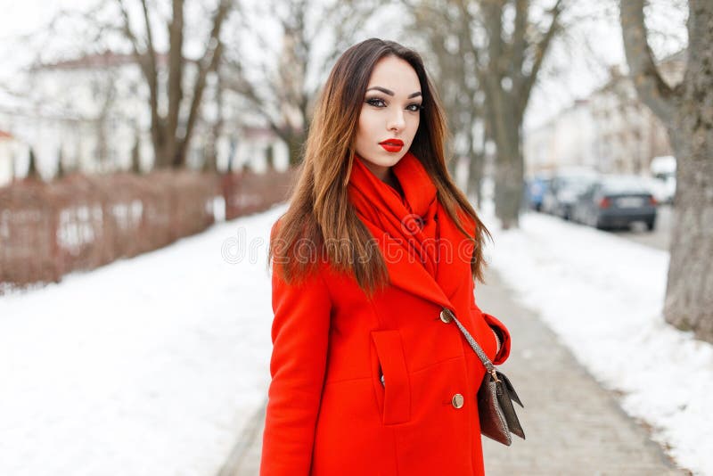 Όμορφο κορίτσι brunette σε ένα κόκκινο φόρεμα που περπατά σε μια χειμερινή ημέρα στοκ φωτογραφία με δικαίωμα ελεύθερης χρήσης