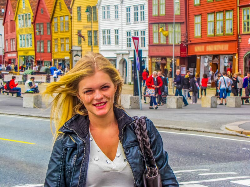 Portrait of beautiful girl in front of the landmark colored houses of Bryggen. In Bergen, Norway. Portrait of beautiful girl in front of the landmark colored houses of Bryggen. In Bergen, Norway