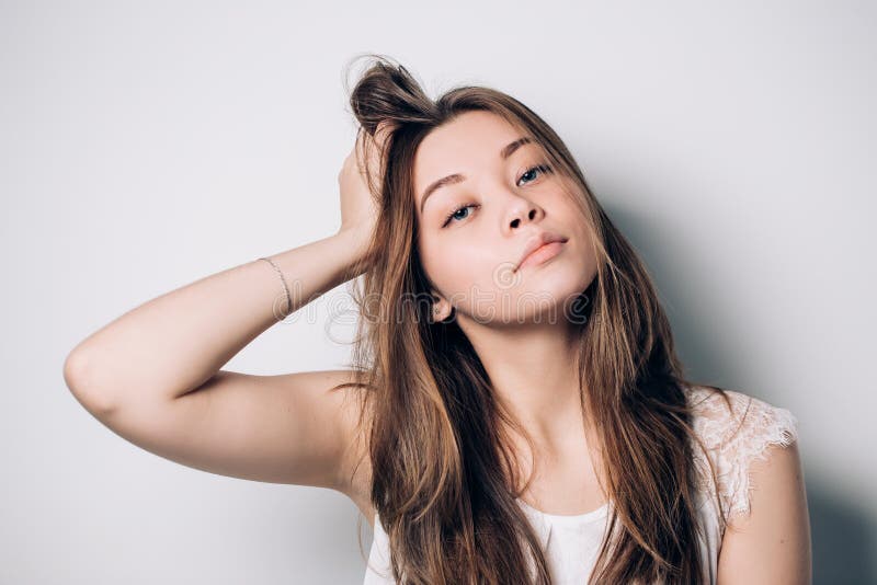 Όμορφο πορτρέτο της νέας γυναίκας brunette με μακρυμάλλη στο άσπρο υπόβαθρο στοκ εικόνα Όμορφο πορτρέτο της νέας γυναίκας brunette με μακρυμάλλη στο άσπρο υπόβαθρο στοκ εικόνα