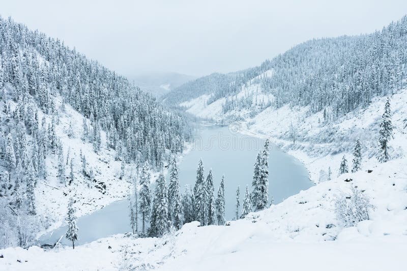 Beautiful lake Amut in taiga hills on Far East of Russia in early october. Mountain lake in winter. Beautiful nature. Snowy weather. Beautiful lake Amut in taiga hills on Far East of Russia in early october. Mountain lake in winter. Beautiful nature. Snowy weather.