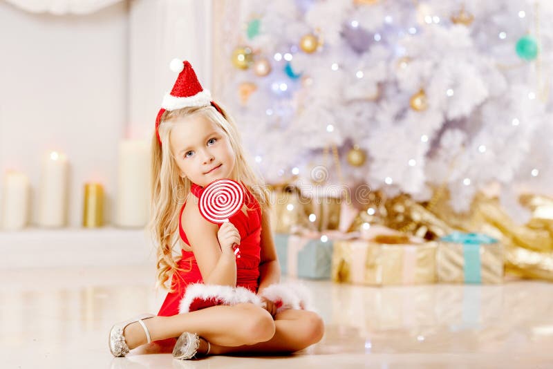 Όμορφος λίγο κορίτσι Santa κοντά στο χριστουγεννιάτικο δέντρο κορίτσι ευτυχές στοκ εικόνες