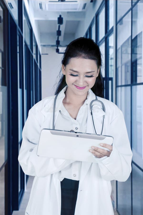 όμορφος γιατρός που χρησιμοποιεί ψηφιακό tablet στο διάδρομο στοκ φωτογραφίες