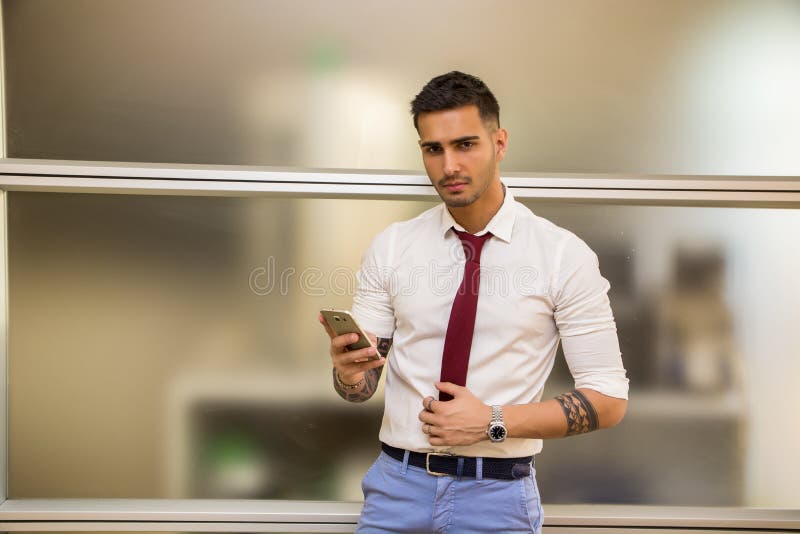 Όμορφος νέος επιχειρηματίας που χρησιμοποιεί το τηλέφωνο κυττάρων στοκ φωτογραφίες με δικαίωμα ελεύθερης χρήσης Όμορφος νέος επιχειρηματίας που χρησιμοποιεί το τηλέφωνο κυττάρων στοκ φωτογραφίες με δικαίωμα ελεύθερης χρήσης
