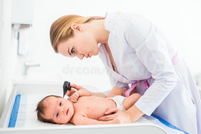 Όμορφος νέος θηλυκός ξανθός γιατρός που εξετάζει λίγο μωρό με το speculum αυτιών στην κλινική Μωρό που κοιτάζει στη κάμερα Υγεία στοκ εικόνες Όμορφος νέος θηλυκός ξανθός γιατρός που εξετάζει λίγο μωρό με το speculum αυτιών στην κλινική Μωρό που κοιτάζει στη κάμερα Υγεία στοκ εικόνες