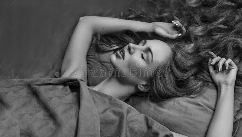 Όμορφος ύπνος γυναικών στο κρεβάτι με την άνεση γλυκό ονείρων πρότυπο με τη σγουρή χαλάρωση τρίχας στα φύλλα