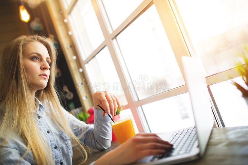 Όνειρα γυναικών freelancer κάτι χαλαρώνοντας συνεδρίαση σε έναν καφέ κοντά σε ένα μεγάλο παράθυρο σε έναν πίνακα με ένα lap-top κ στοκ εικόνες με δικαίωμα ελεύθερης χρήσης Όνειρα γυναικών freelancer κάτι χαλαρώνοντας συνεδρίαση σε έναν καφέ κοντά σε ένα μεγάλο παράθυρο σε έναν πίνακα με ένα lap-top κ στοκ εικόνες με δικαίωμα ελεύθερης χρήσης