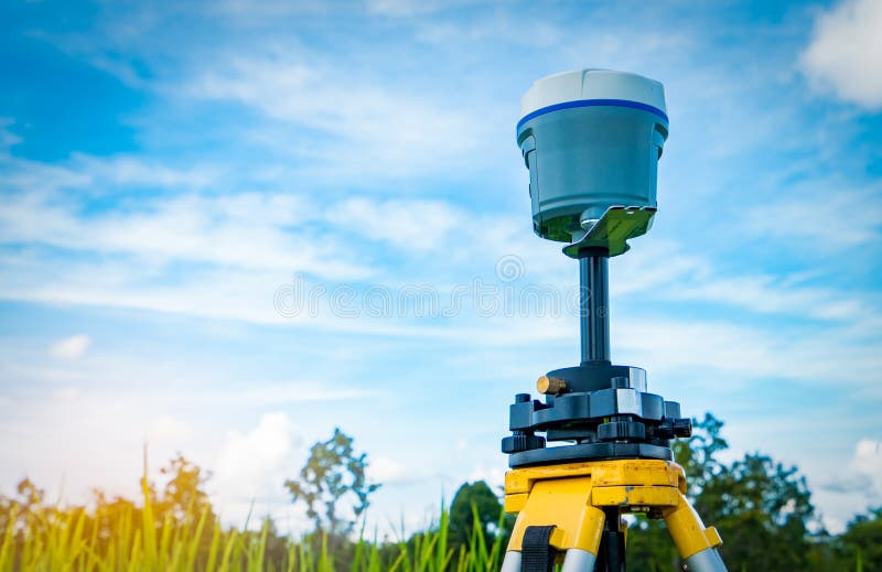 GPS surveying instrument on blue sky and rice field background. GPS surveying instrument on blue sky and rice field background