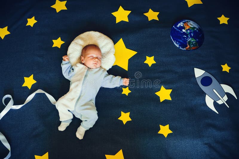 Ύπνος μωρών μικρών παιδιών σε ένα κοστούμι του αστροναύτη στο υπόβαθρο του έναστρου ουρανού στοκ εικόνες Ύπνος μωρών μικρών παιδιών σε ένα κοστούμι του αστροναύτη στο υπόβαθρο του έναστρου ουρανού στοκ εικόνες