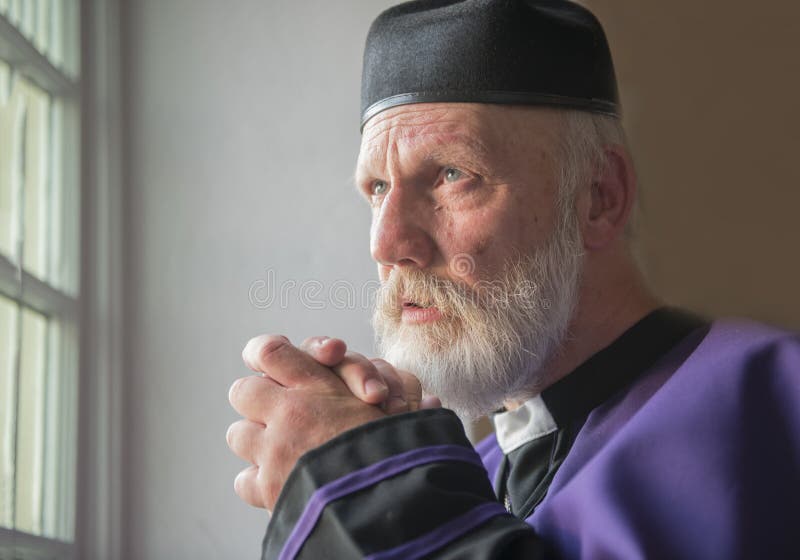 Ώριμος ιερέας που προσεύχεται σε μια εκκλησία στοκ εικόνες Ώριμος ιερέας που προσεύχεται σε μια εκκλησία στοκ εικόνες
