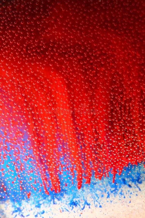 Abstract of red and blue inks in a clear liquid. Gives the appearance of overlapping red, white and blue. Small air bubbles throughout. Abstract of red and blue inks in a clear liquid. Gives the appearance of overlapping red, white and blue. Small air bubbles throughout.
