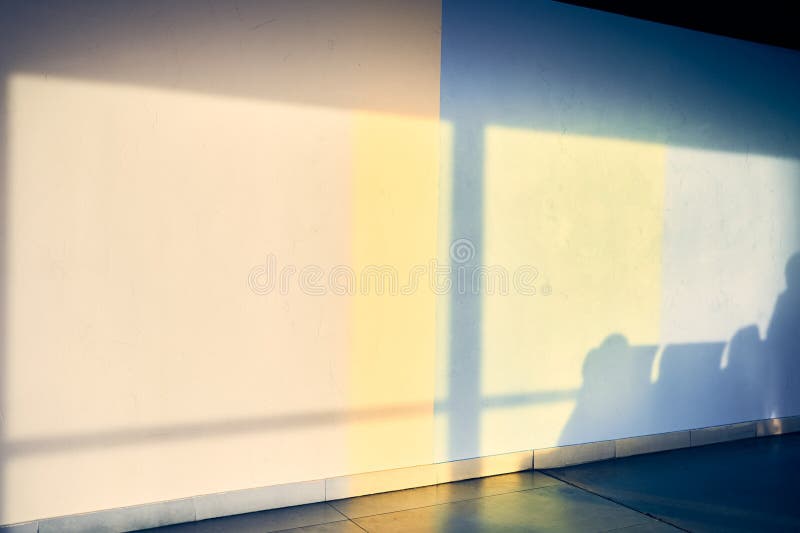 An abstract background depicting the shadow of a row of chairs on a white wall at the airport, with space to copy. Bright light from the sun. High quality photo. An abstract background depicting the shadow of a row of chairs on a white wall at the airport, with space to copy. Bright light from the sun. High quality photo