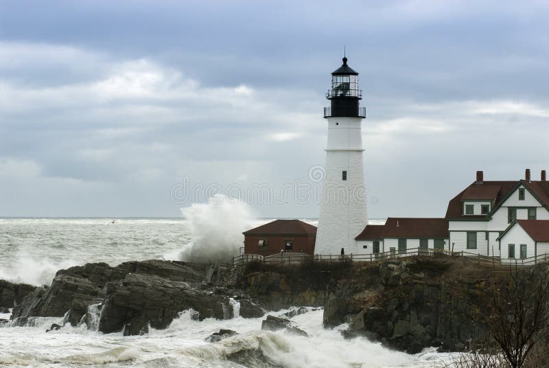 Huge waves crash against Portland Head lighthouse as sunlight breaks through storm clouds. It is the oldest lighthouse in Maine, and the second oldest in the United States. Huge waves crash against Portland Head lighthouse as sunlight breaks through storm clouds. It is the oldest lighthouse in Maine, and the second oldest in the United States.