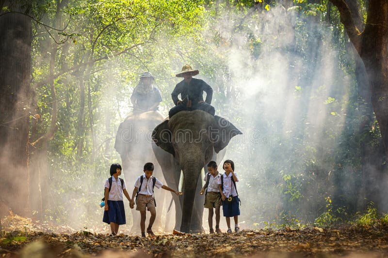Азиат Mahout и студента маленький в форме поднимает слонов на дорожке в девушке и мальчике студента леса маленькой азиатских sing стоковые изображения Азиат Mahout и студента маленький в форме поднимает слонов на дорожке в девушке и мальчике студента леса маленькой азиатских sing стоковые изображения