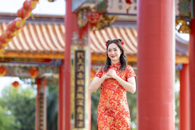 азиатка в красном платье cheongsam qipao загадывает желание богу предков внутри китайского буддистского храма во время лунного нов стоковое изображение rf