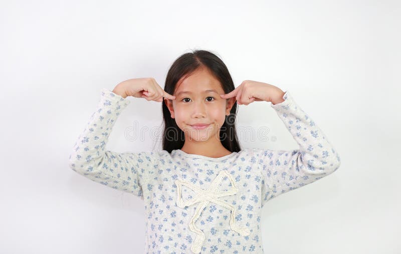 Молодая азиатская девочка задумалась, жест двумя указательными пальцами, указывающими на голову, на белом фоне стоковая фотография