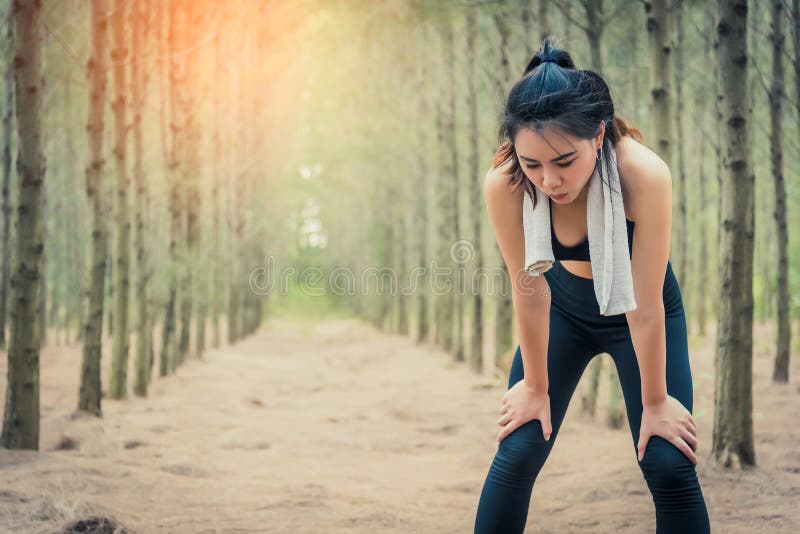Азиатская женщина красоты утомляя от jogging в элементах полотенца и пота леса Спорт и здоровая концепция Jogging и идущая концеп стоковые изображения rf Азиатская женщина красоты утомляя от jogging в элементах полотенца и пота леса Спорт и здоровая концепция Jogging и идущая концеп стоковые изображения rf