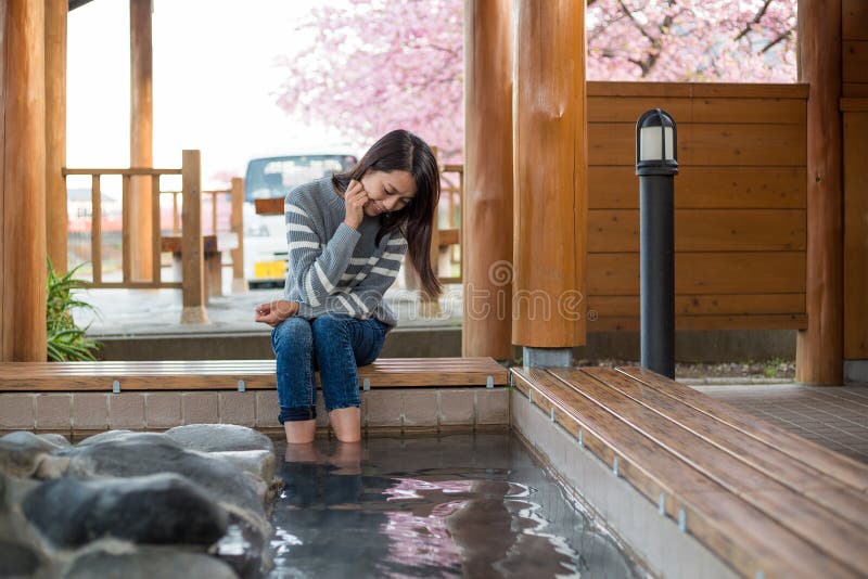 Азиатская женщина наслаждается ее ногой onsen