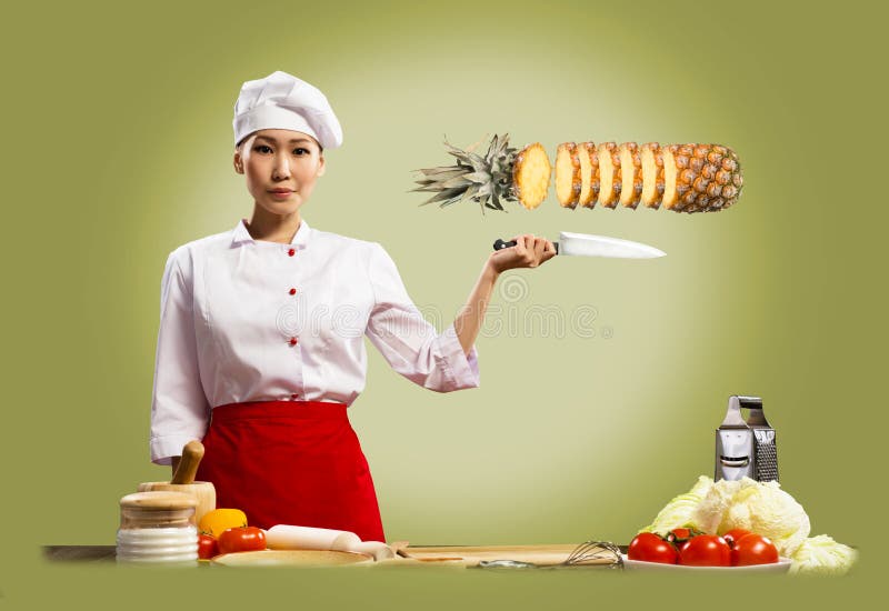 Asian female chef cuts pineapple, creative cuisine. Asian female chef cuts pineapple, creative cuisine