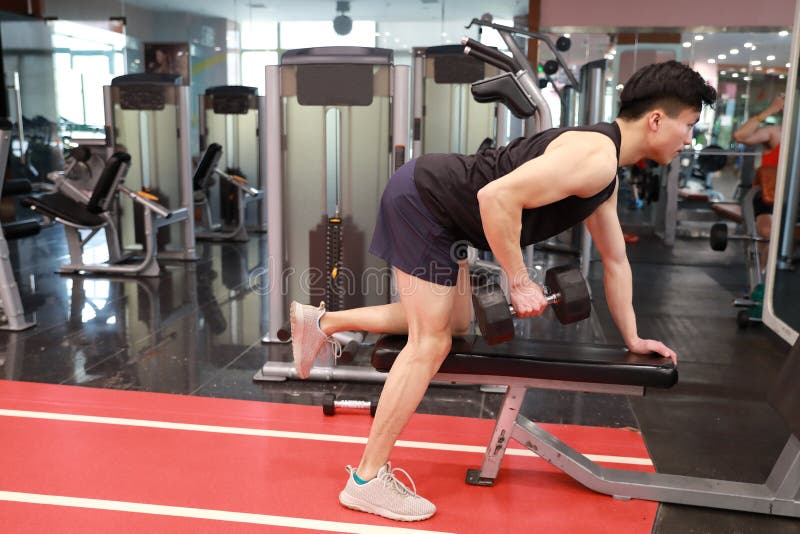 Азиатский китайский человек в молодом человеке ŒFitness ¼ ï спортзала в спортзале делая тренировки с гантелями стоковые фото Азиатский китайский человек в молодом человеке ŒFitness ¼ ï спортзала в спортзале делая тренировки с гантелями стоковые фото