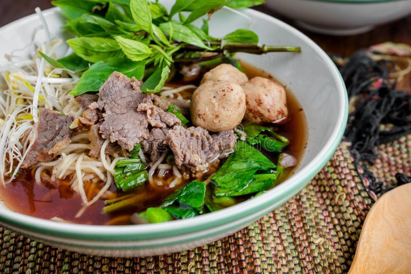 Asian noodle soup with beef meatball with fresh vegetable on wood table vintage style, street food, hot and spicy noodle soup, asian food. Asian noodle soup with beef meatball with fresh vegetable on wood table vintage style, street food, hot and spicy noodle soup, asian food