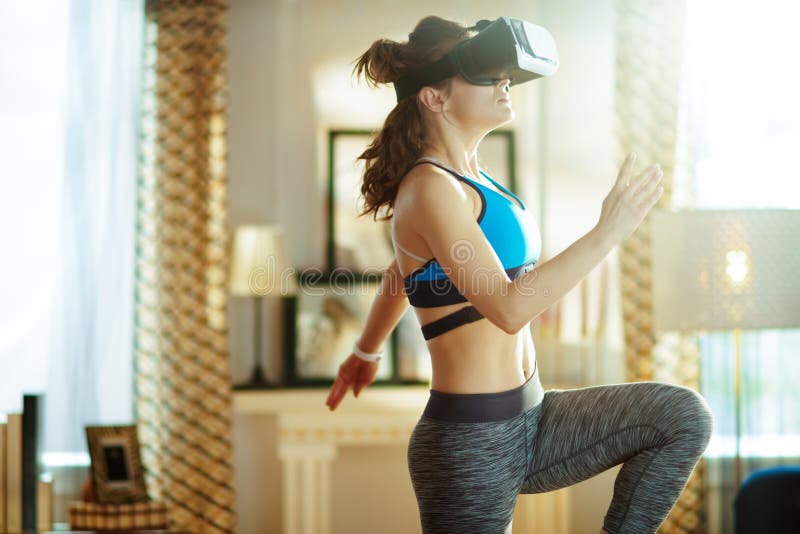 Активная женщина спорт на современном доме в разминке стекел VR стоковая фотография rf Активная женщина спорт на современном доме в разминке стекел VR стоковая фотография rf