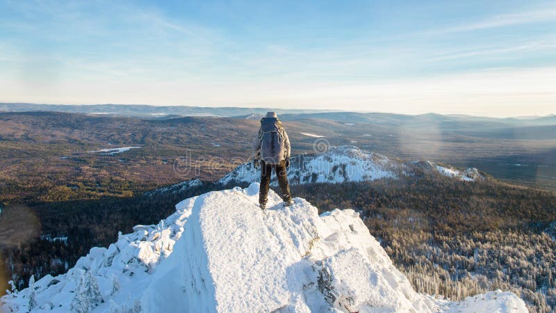 Альпинист взобрался верхняя часть горы, hiker человека стоя на пике утеса покрытом с льдом и снег, взгляд от стоковые фотографии rf Альпинист взобрался верхняя часть горы, hiker человека стоя на пике утеса покрытом с льдом и снег, взгляд от стоковые фотографии rf