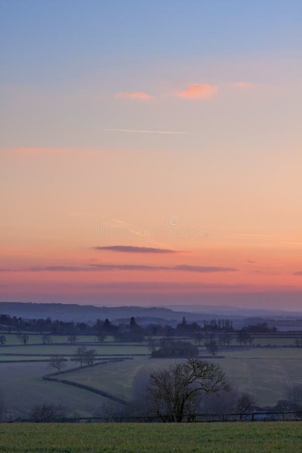 A zoomed view over English countryside at sunset. Photo taken on a winter afternoon at sunset. A zoomed view over English countryside at sunset. Photo taken on a winter afternoon at sunset.