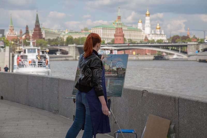 Анонимный молодой женский художник картины на ландшафте Москвы воздуха plein работы стоковые фотографии rf Анонимный молодой женский художник картины на ландшафте Москвы воздуха plein работы стоковые фотографии rf