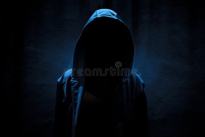 Woman wearing hoodie standing in the dark,Scary background for book cover. Woman wearing hoodie standing in the dark,Scary background for book cover