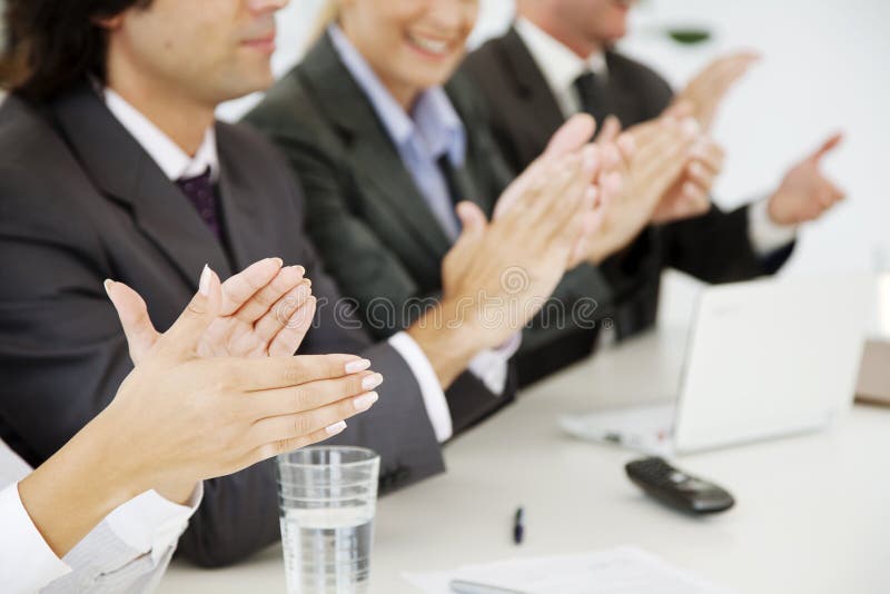 Business people at a board meeting, clapping. Business people at a board meeting, clapping
