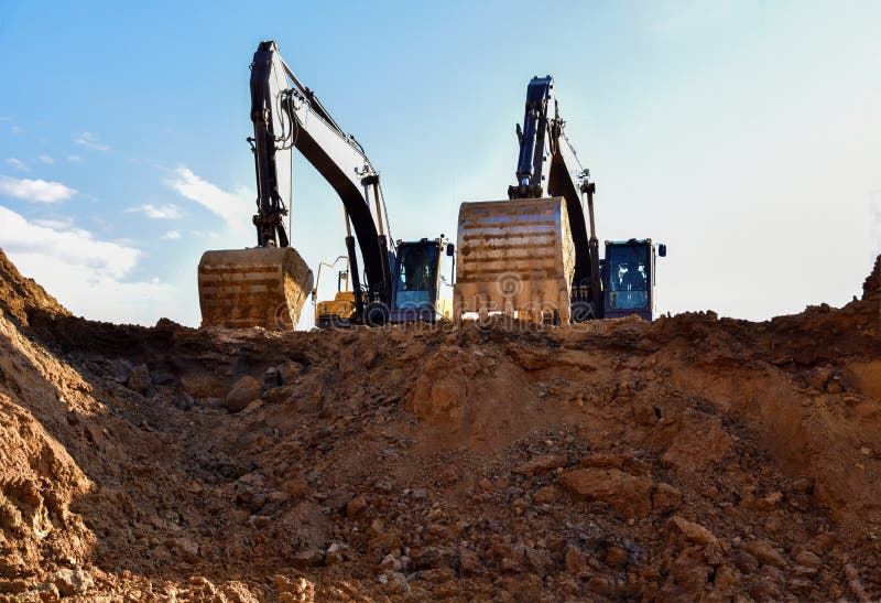 Археологи во время earthmoving на открытом карьере на фоне голубого неба.. Строительная техника и earthmoving тяжелое оборудование стоковое фото rf