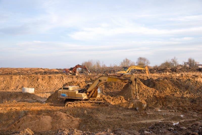 Археологи, работающие на openpit горнодобывающей промышленности. Экскаватор во время earthworks на карьере песка. Earthmoving тяже стоковые изображения rf