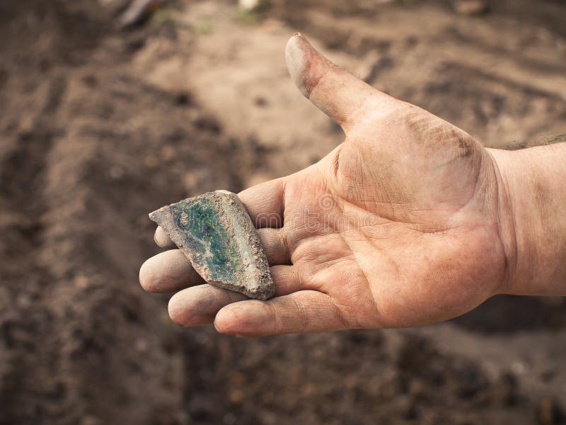 Fragment of ancient ceramic tiles on hand archaeologist. Fragment of ancient ceramic tiles on hand archaeologist
