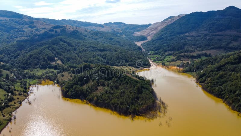 Aerial View Over a Big Waste Lake Polluted With Toxic Mining Residuals Tailings From an Open Pit Copper Mine in Geamana, Rosia Poieni, Romania. Aerial View Over a Big Waste Lake Polluted With Toxic Mining Residuals Tailings From an Open Pit Copper Mine in Geamana, Rosia Poieni, Romania