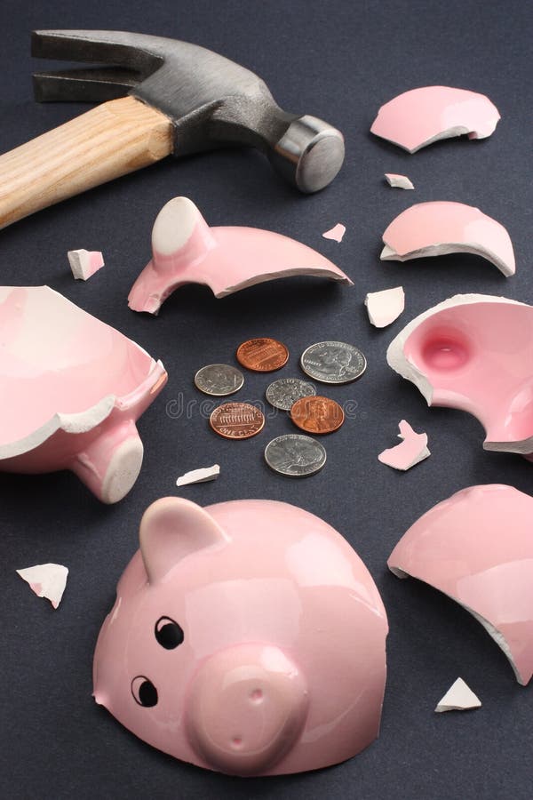 Broken piggy bank containing few coins conveying a sense of misery and financial despair. Business & Finance Collection. Broken piggy bank containing few coins conveying a sense of misery and financial despair. Business & Finance Collection.