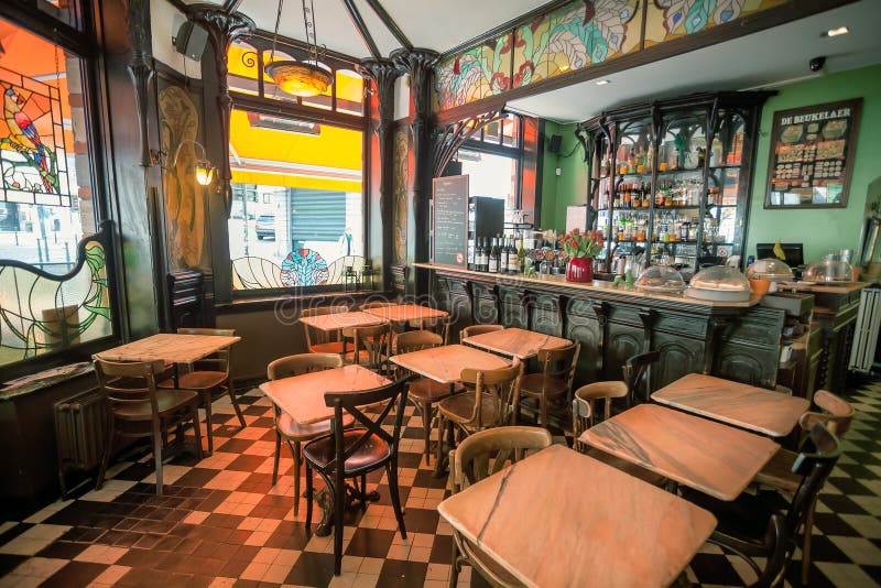 BRUSSELS, BELGIUM - APR 2: Bar and empty tables inside artistic cafe with antique furniture in Art Nouveau style and stained-glass windows on April 2 2018. More than 1,200,000 people lives in Brussels. BRUSSELS, BELGIUM - APR 2: Bar and empty tables inside artistic cafe with antique furniture in Art Nouveau style and stained-glass windows on April 2 2018. More than 1,200,000 people lives in Brussels