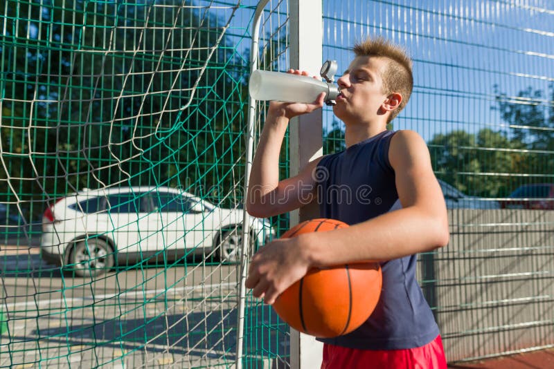 Баскетболист подростка мальчика мяч из бутылки с питьевой водой