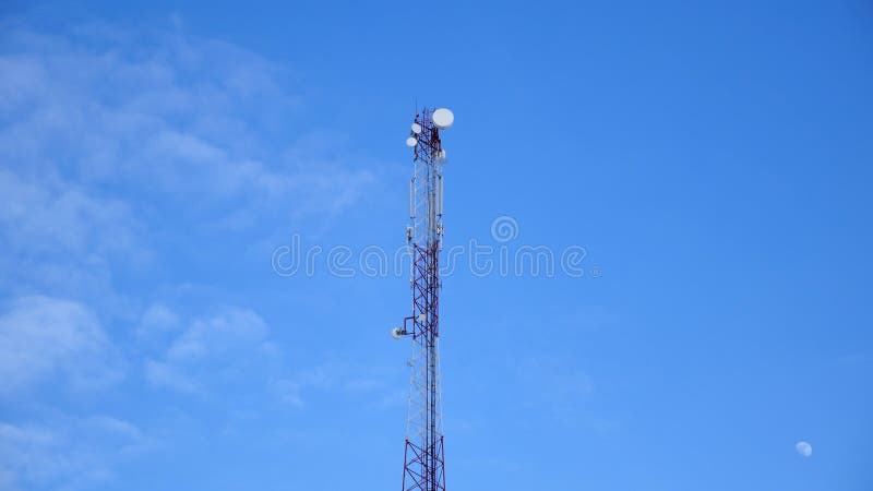 Башенные антенны, мобильная телефонная связь GSM против голубого неба с луной стоковая фотография rf Башенные антенны, мобильная телефонная связь GSM против голубого неба с луной стоковая фотография rf