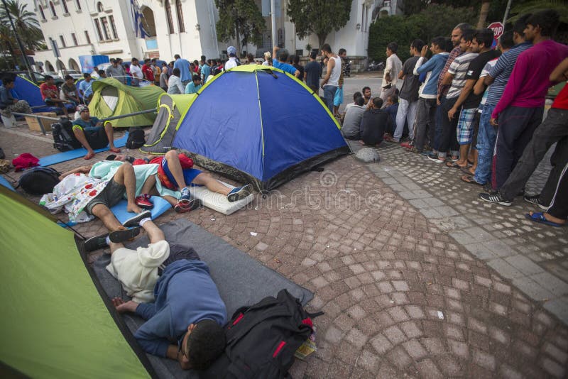 KOS, GREECE - SEP 28, 2015: Unidentified war refugees near tents. More than half are migrants from Syria, but there are refugees from other countries -Afghanistan, Pakistan, Iraq, Iran, Mali, Somalia. KOS, GREECE - SEP 28, 2015: Unidentified war refugees near tents. More than half are migrants from Syria, but there are refugees from other countries -Afghanistan, Pakistan, Iraq, Iran, Mali, Somalia.