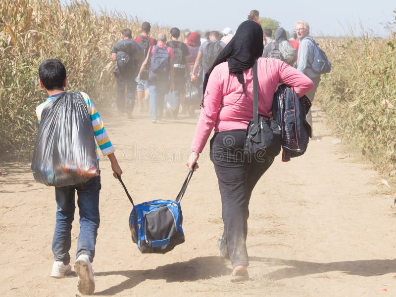 Picture of a groupe of family of refugees, carrying heavy luggage, mainly from iraq, Syria and Afghanistan, walking through the fields near border crossing of Sid Tovarnik, between Croatia and Serbia. This bo. Picture of a groupe of family of refugees, carrying heavy luggage, mainly from iraq, Syria and Afghanistan, walking through the fields near border crossing of Sid Tovarnik, between Croatia and Serbia. This bo