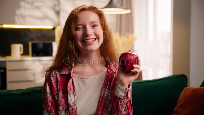Беззаботная кавказка девочка-подросток улыбается самке держа дома красное яблоко, счастливая со здоровьем сток-видео