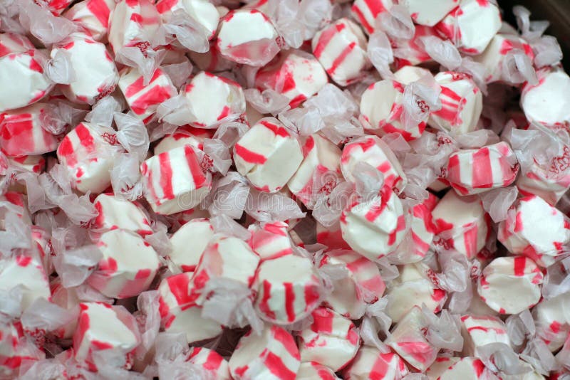 Lots of colorful red and white peppermint salt water taffy candies. Lots of colorful red and white peppermint salt water taffy candies