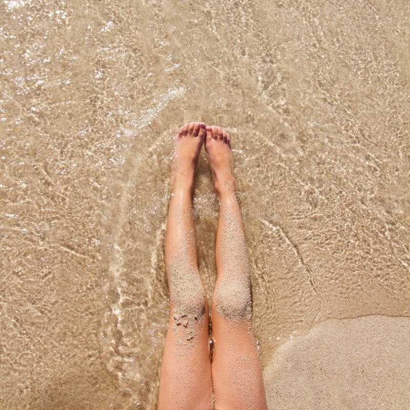 Children girl legs in beach sand shore at summer vacation. Children girl legs in beach sand shore at summer vacation