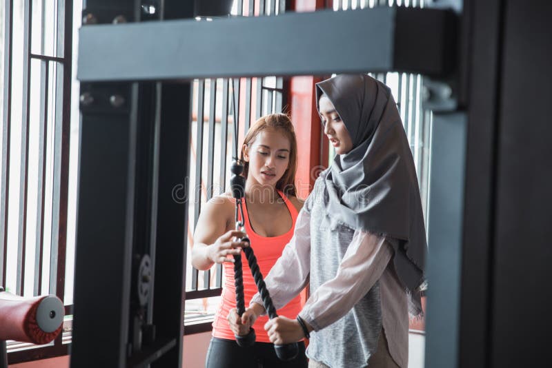 Беспристрастный взгляд молодого азиатского мусульманского hijab женщины работая трицепс стоковое фото Беспристрастный взгляд молодого азиатского мусульманского hijab женщины работая трицепс стоковое фото