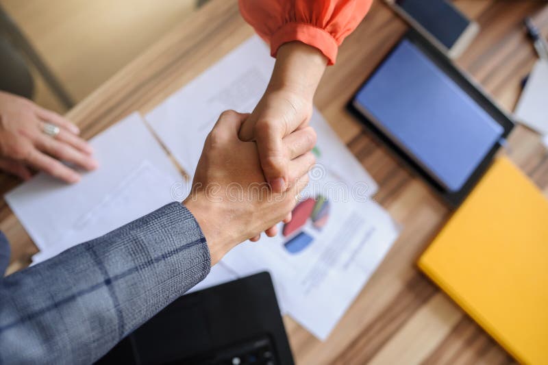 Бизнес-леди и человек на handshaking стола офиса, только руки стоковое фото Бизнес-леди и человек на handshaking стола офиса, только руки стоковое фото