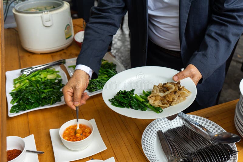 Business man in business suit preparing the Fried noodle with pork and  broccoli for lunch. Business man in business suit preparing the Fried noodle with pork and  broccoli for lunch